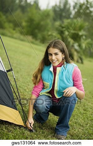 Portrait of a teenage girl crouching besides a tent View Large Photo Image Picture - Portrait of a teenage girl crouching besides a tent. Fotosearch