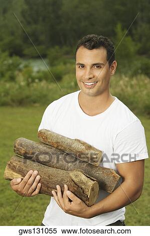 Portrait of a young man carrying firewood View Large Photo Image Stock Photography - Portrait of a young man carrying firewood. Fotosearch