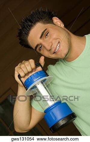 Portrait of a young man holding a lantern View Large Photo Image Picture - Portrait of a young man holding a lantern. Fotosearch