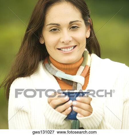 Portrait of a young woman holding a cup View Large Photo Image Stock Photo - Portrait of a young woman holding a cup. Fotosearch