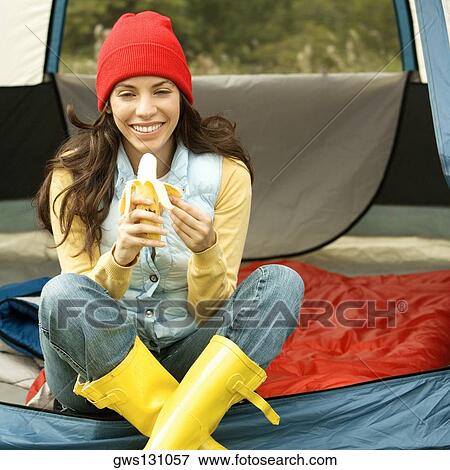 Portrait of a young woman peeling a banana View Large Photo Image Stock Photo - Portrait of a young woman peeling a banana. Fotosearch