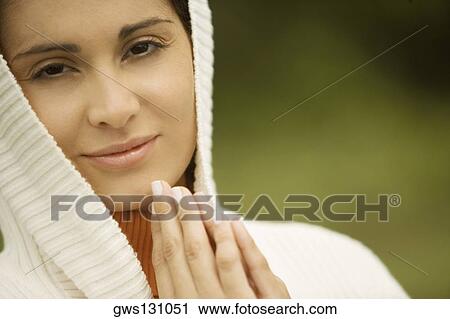 Stock Image - Portrait of a young woman smiling in a prayer position. Fotosearch