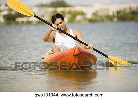 Picture - Young man kayaking in a lake. Fotosearch