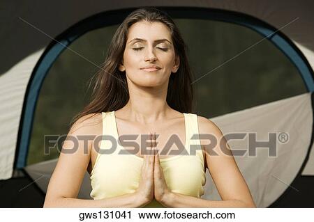 Young woman sitting in a prayer position View Large Photo Image Stock Image - Young woman sitting in a prayer position. Fotosearch