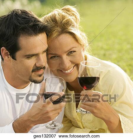 Close-up of a mature man and a young woman holding glasses of red wine View Large Photo Image Stock Photo - Close-up of a mature man and a young woman holding glasses of red wine. Fotosearch