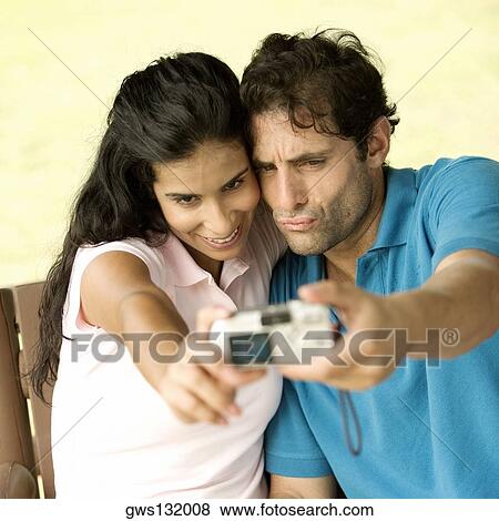 Close-up of a mid adult man and a young woman taking a photograph of themselves View Large Photo Image Stock Photo - Close-up of a mid adult man and a young woman taking a photograph of themselves. Fotosearch