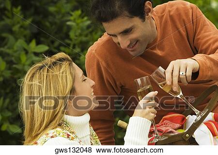 Close-up of a mid adult man and a young woman toasting with wineglasses View Large Photo Image Stock Photo - Close-up of a mid adult man and a young woman toasting with wineglasses. Fotosearch