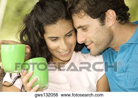 Close-up of a mid adult man and a young woman holding coffee cups View Large Photo Image Stock Photograph - Close-up of a mid adult man and a young woman holding coffee cups. Fotosearch