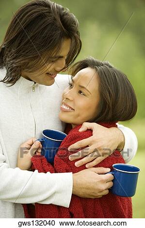 Stock Image - Close-up of a young man embracing a young woman. Fotosearch