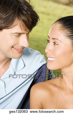 Close-up of a young woman and a mid adult man smiling View Large Photo Image Stock Image - Close-up of a young woman and a mid adult man smiling. Fotosearch