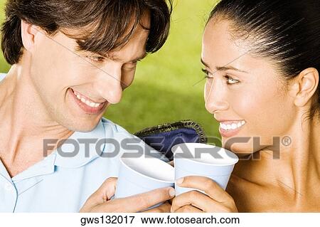 Stock Photo - Close-up of a young woman and a mid adult man smiling. Fotosearch