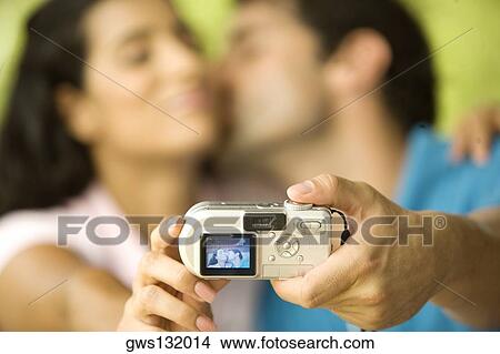 Mid adult man and a young woman taking a photograph of themselves View Large Photo Image Picture - Mid adult man and a young woman taking a photograph of themselves. Fotosearch