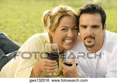 Portrait of a mature man and a young woman holding glasses of red wine View Large Photo Image Stock Photograph - Portrait of a mature man and a young woman holding glasses of red wine. Fotosearch