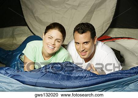 Portrait of a young couple lying in a tent View Large Photo Image Stock Image - Portrait of a young couple lying in a tent. Fotosearch