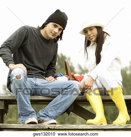 Portrait of a young couple sitting together View Large Photo Image Stock Image - Portrait of a young couple sitting together. Fotosearch