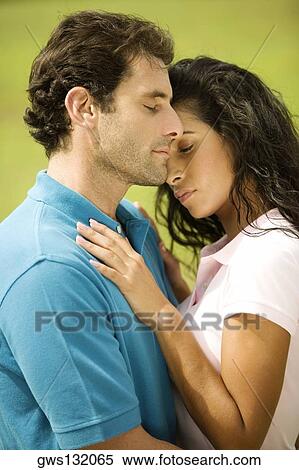 Side profile of a mid adult man embracing a young woman View Large Photo Image Stock Photography - Side profile of a mid adult man embracing a young woman. Fotosearch