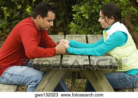 Side profile of a young couple holding hands View Large Photo Image Stock Image - Side profile of a young couple holding hands. Fotosearch