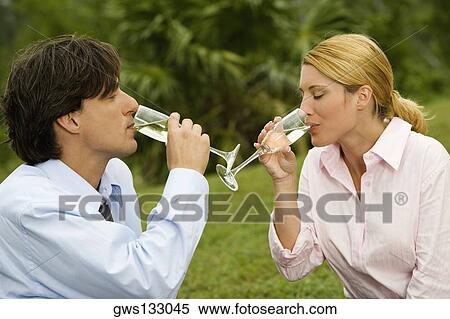 Stock Photography - Close-up of a businessman and a businesswoman drinking champagne. Fotosearch
