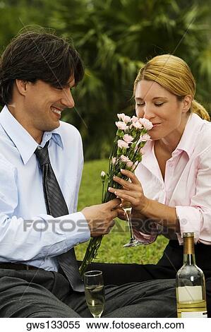 Close-up of a businessman holding a bunch of flowers with a businesswoman smelling them View Large Photo Image Stock Photography - Close-up of a businessman holding a bunch of flowers with a businesswoman smelling them. Fotosearch