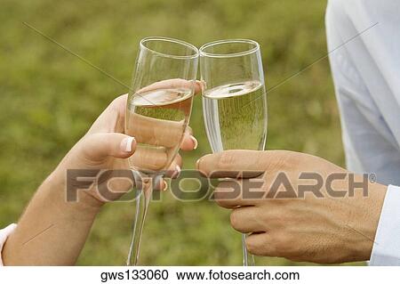 Close-up of a man and a woman toasting champagne flutes View Large Photo Image Stock Image - Close-up of a man and a woman toasting champagne flutes. Fotosearch