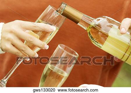 Close-up of a person's hand pouring champagne View Large Photo Image Stock Image - Close-up of a person's hand pouring champagne. Fotosearch