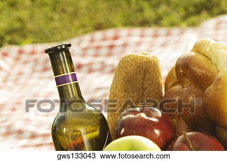 Close-up of a wine bottle with bread and fruits in a picnic basket View Large Photo Image Stock Image - Close-up of a wine bottle with bread and fruits in a picnic basket. Fotosearch