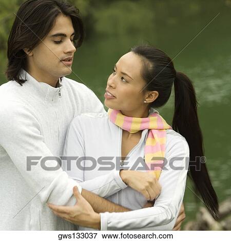 Stock Photo - Close-up of a young man embracing a young woman. Fotosearch