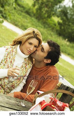 Mid adult man kissing a young woman View Large Photo Image Stock Image - Mid adult man kissing a young woman. Fotosearch