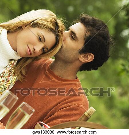 Stock Photo - Mid adult man kissing a young woman. Fotosearch