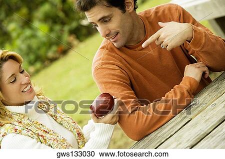 Stock Image - Mid adult man talking to a young woman. Fotosearch