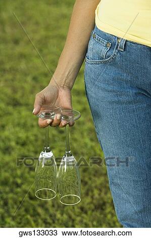 Mid section view of a woman holding two empty champagne flutes View Large Photo Image Stock Image - Mid section view of a woman holding two empty champagne flutes. Fotosearch