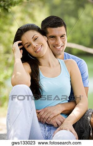 Portrait of a mid adult man embracing a young woman from behind View Large Photo Image Stock Image - Portrait of a mid adult man embracing a young woman from behind. Fotosearch