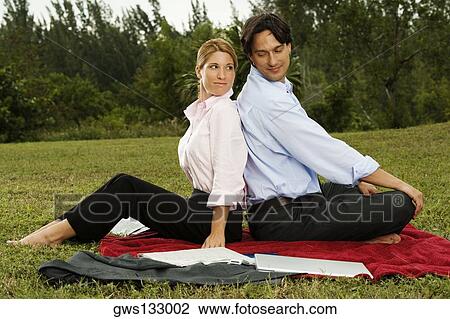 Side profile of a businessman and a businesswoman sitting back to back in the park View Large Photo Image Stock Image - Side profile of a businessman and a businesswoman sitting back to back in the park. Fotosearch