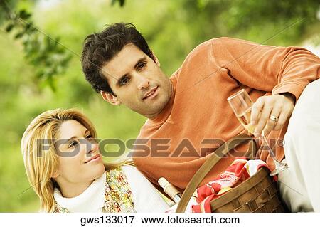 Young woman and a mid adult man holding champagne flutes View Large Photo Image Stock Photo - Young woman and a mid adult man holding champagne flutes. Fotosearch