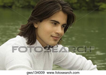 Close-up of a young man thinking View Large Photo Image Stock Photo - Close-up of a young man thinking. Fotosearch