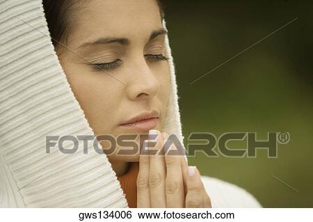 Close-up of a young woman praying with her eyes closed View Large Photo Image Stock Photograph - Close-up of a young woman praying with her eyes closed. Fotosearch