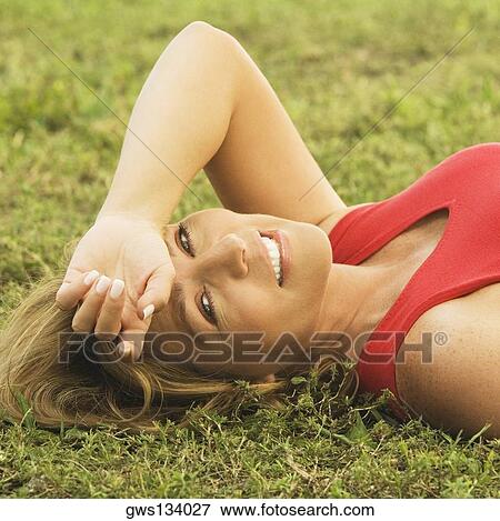 Portrait of a mature woman lying on the lawn View Large Photo Image Stock Photo - Portrait of a mature woman lying on the lawn. Fotosearch