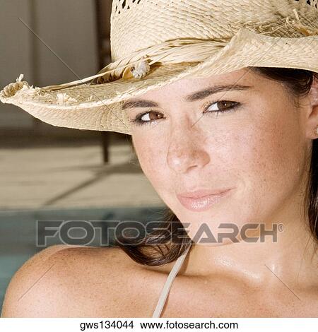 Portrait of a young woman wearing a straw hat View Large Photo Image Picture - Portrait of a young woman wearing a straw hat. Fotosearch