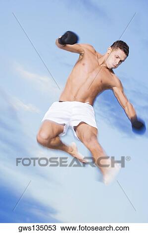 Low angle view of a young man jumping View Large Photo Image Stock Image - Low angle view of a young man jumping. Fotosearch
