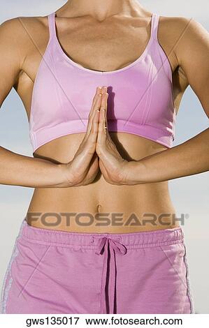 Mid section view of a mid adult woman standing in a prayer position View Large Photo Image Stock Photo - Mid section view of a mid adult woman standing in a prayer position. Fotosearch