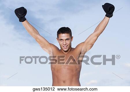 Portrait of a young man smiling with his arms raised View Large Photo Image Stock Image - Portrait of a young man smiling with his arms raised. Fotosearch