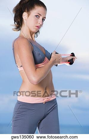 Portrait of a young woman exercising with a resistance band View Large Photo Image Stock Image - Portrait of a young woman exercising with a resistance band. Fotosearch