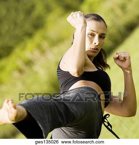 Portrait of a young woman practicing martial arts View Large Photo Image Stock Photograph - Portrait of a young woman practicing martial arts. Fotosearch