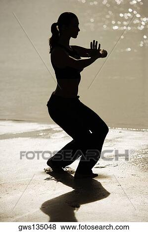 Silhouette of a young woman practicing martial arts on the beach View Large Photo Image Stock Photo - Silhouette of a young woman practicing martial arts on the beach. Fotosearch