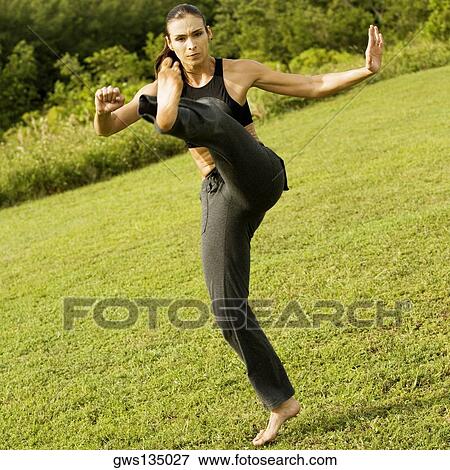 Stock Photo - Young woman practicing martial arts. Fotosearch