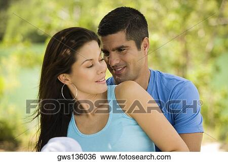 Close-up of a mid adult man embracing a young woman from behind View Large Photo Image Stock Photograph - Close-up of a mid adult man embracing a young woman from behind. Fotosearch