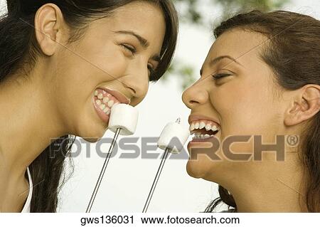 Close-up of two teenage girls eating marshmallows View Large Photo Image Stock Image - Close-up of two teenage girls eating marshmallows. Fotosearch