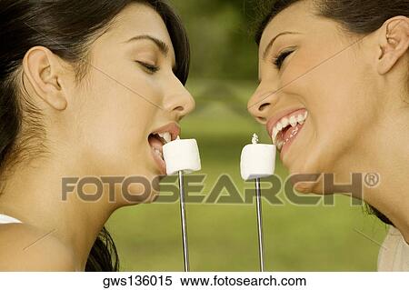 Close-up of two teenage girls eating marshmallows View Large Photo Image Stock Photography - Close-up of two teenage girls eating marshmallows. Fotosearch