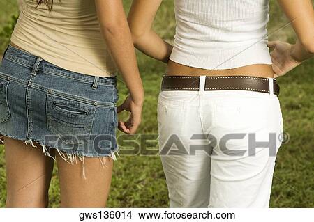 Mid section view of two teenage girls standing side by side View Large Photo Image Picture - Mid section view of two teenage girls standing side by side. Fotosearch