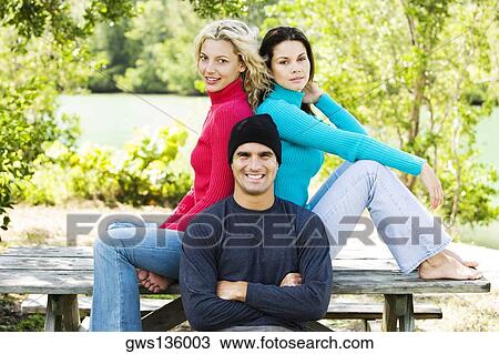 Portrait of a mid adult man and two young women smiling View Large Photo Image Stock Image - Portrait of a mid adult man and two young women smiling. Fotosearch